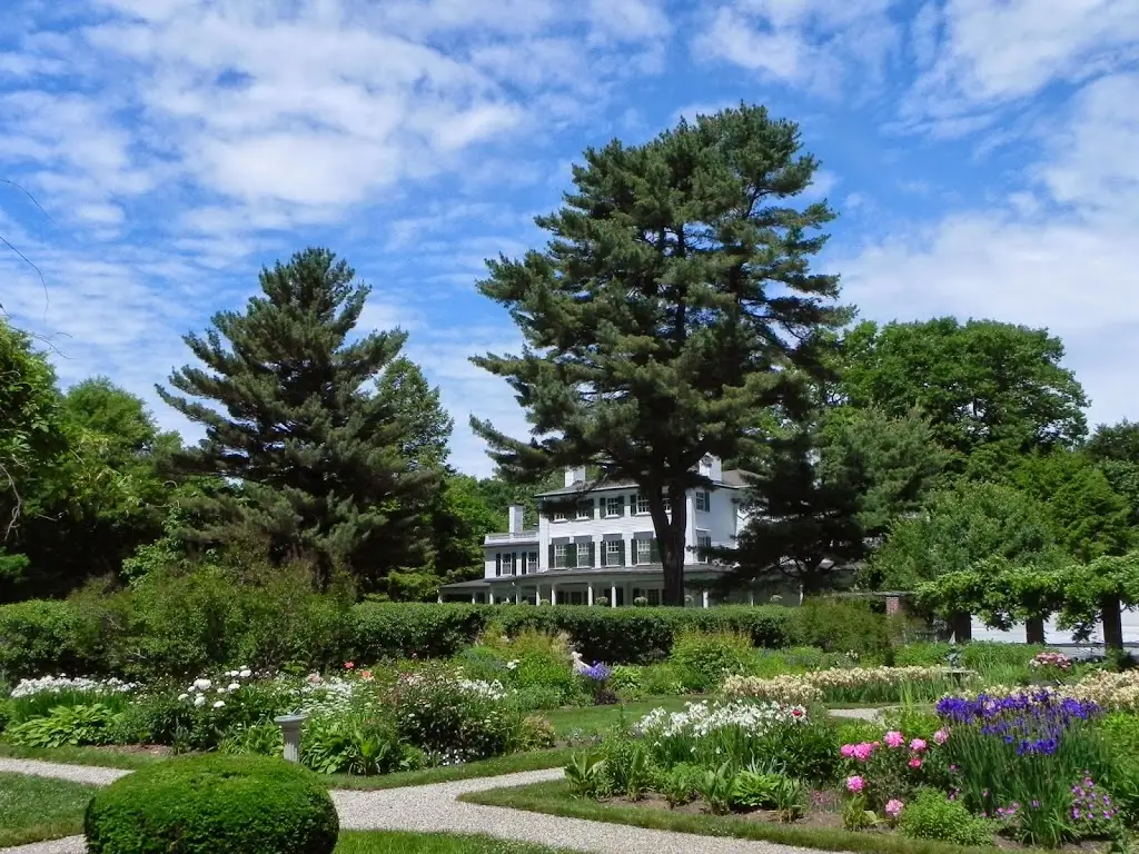 The mansion and formal gardens at Glen Magna Farms under a blue sky