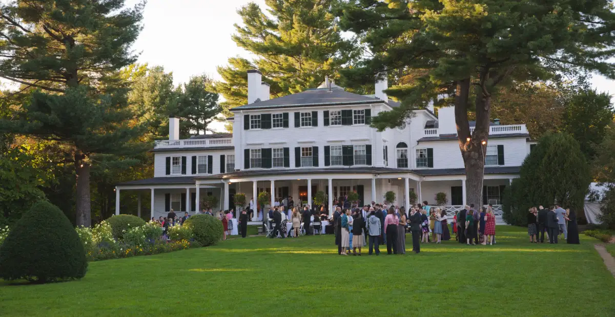 Guests gathered on the lawn in front of the mansion