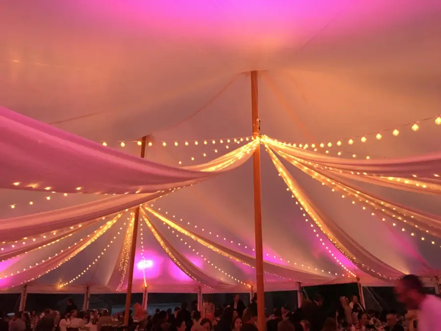 Guests dancing under the sailcloth tent with string lights